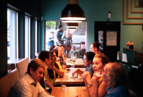 People sitting at tables, talking, at a busy restaurant